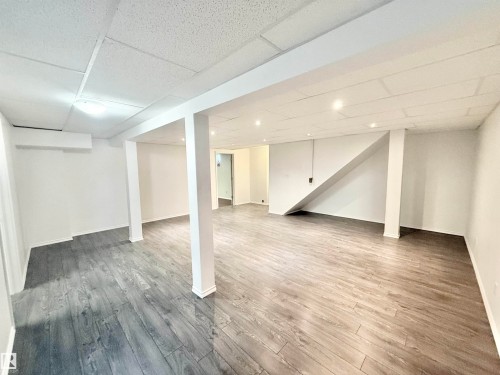 Finished basement featuring a drop ceiling and wood finished floors - 2112 104B Street, Edmonton, AB - Indoor