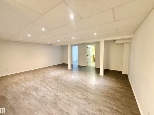 Finished below grade area with light wood-type flooring and a paneled ceiling - 2112 104B Street, Edmonton, AB - Indoor