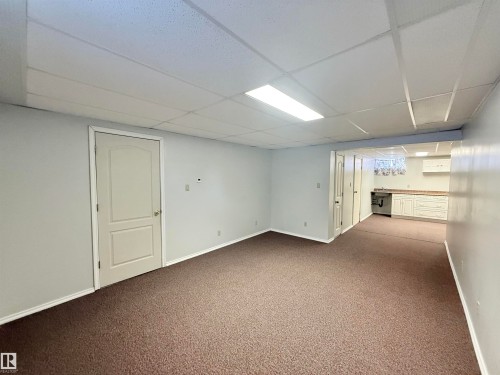Finished basement featuring a paneled ceiling and carpet floors - 2112 104B Street, Edmonton, AB - Indoor