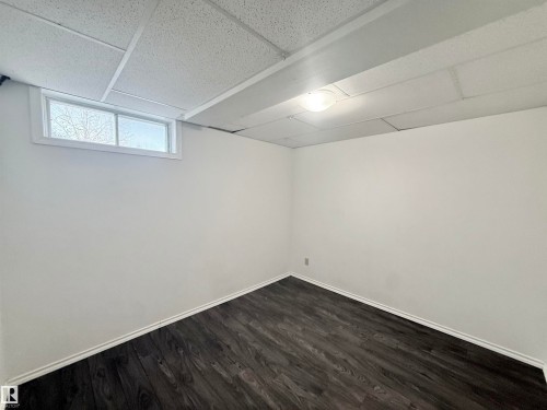 Below grade area with dark wood-style flooring and a paneled ceiling - 2112 104B Street, Edmonton, AB - Indoor Photo Showing Other Room