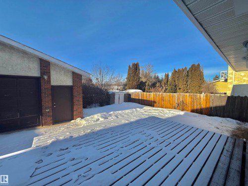 Snow covered deck featuring a storage unit, a fenced backyard, and a garage - 2112 104B Street, Edmonton, AB - Outdoor