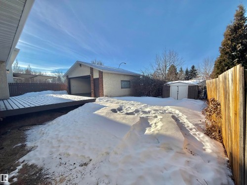 View of front facade with a fenced backyard, brick siding, a wooden deck, and a storage shed - 2112 104B Street, Edmonton, AB - Outdoor
