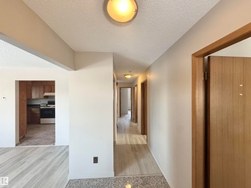 Corridor featuring a textured ceiling and light wood-style floors - 2112 104B Street, Edmonton, AB - Indoor Photo Showing Other Room