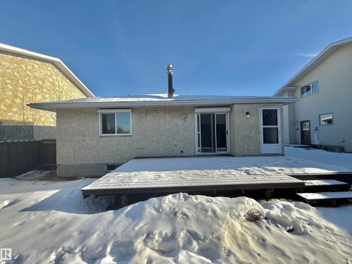 Snow covered property featuring stucco siding and a deck - 2112 104B Street, Edmonton, AB - Outdoor