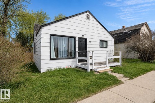 White siding exterior with a dark front door and window frames - 4922 47 Ave, St. Paul Town, AB - Outdoor