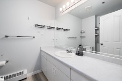 Bathroom featuring a baseboard heating unit, vanity, and dark wood-style floors - 