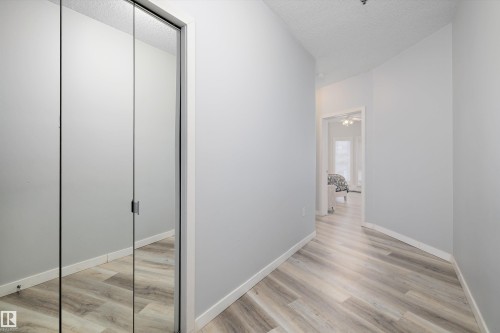 Corridor with light wood-style flooring and a textured ceiling - 205 10809 Saskatchewan Drive, Edmonton, AB - Indoor Photo Showing Other Room