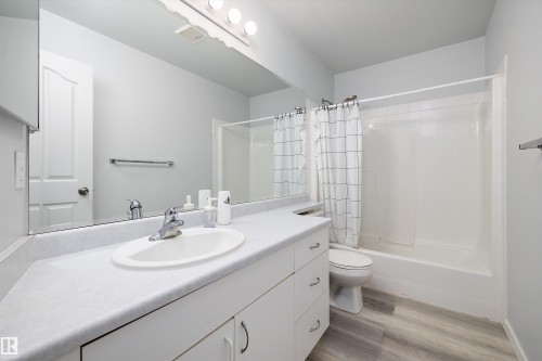 Bathroom with vanity, shower / bath combo with shower curtain, and light wood-style floors - 205 10809 Saskatchewan Drive, Edmonton, AB - Indoor Photo Showing Bathroom