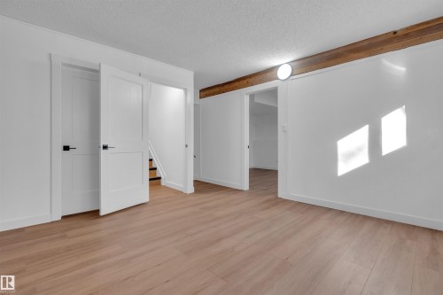 Unfurnished bedroom featuring a textured ceiling and light wood finished floors - 1111 49A Street, Edmonton, AB - Indoor Photo Showing Other Room
