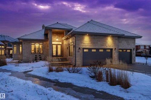 Modern home featuring a chimney, stone siding, a garage, and concrete driveway - 2796 Wheaton Drive, Edmonton, AB - Outdoor