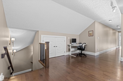Office area featuring a textured ceiling, dark wood-style floors, and vaulted ceiling - 2796 Wheaton Drive, Edmonton, AB - Indoor