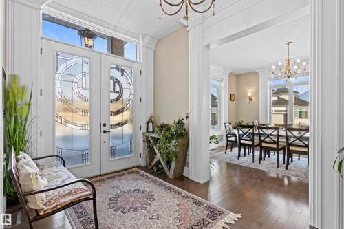 Foyer entrance with a chandelier, a textured ceiling, dark wood finished floors, and french doors - 2796 Wheaton Drive, Edmonton, AB - Indoor Photo Showing Other Room