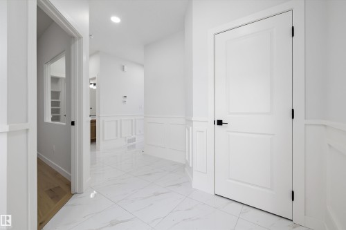 Hall with light marble finish flooring, wainscoting, a decorative wall, and recessed lighting - 230 Edgemont Green Green Nw, Edmonton, AB - Indoor Photo Showing Other Room