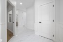 Hall with light marble finish flooring, wainscoting, a decorative wall, and recessed lighting - 230 Edgemont Green Green Nw, Edmonton, AB  - Indoor Photo Showing Other Room 