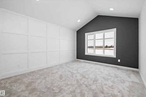 Empty room featuring light carpet, recessed lighting, and a decorative wall - 230 Edgemont Green Green Nw, Edmonton, AB - Indoor Photo Showing Other Room