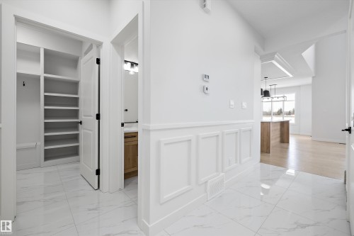 Hallway with light marble finish floors, a decorative wall, and a wainscoted wall - 230 Edgemont Green Green Nw, Edmonton, AB - Indoor Photo Showing Other Room