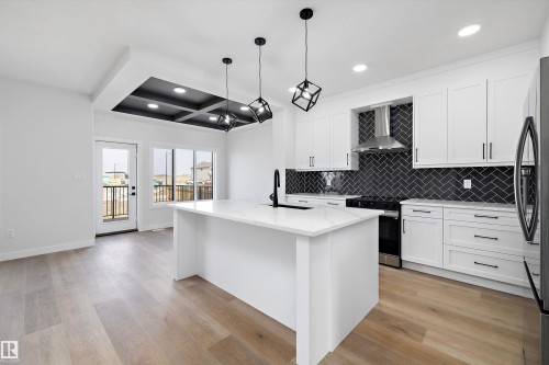 Kitchen with coffered ceiling, an island with sink, recessed lighting, black electric range, and white cabinets - 38 Cannes Cove, St. Albert, AB - Indoor Photo Showing Kitchen With Upgraded Kitchen