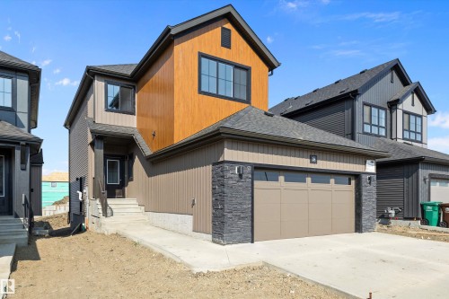 View of front of home with roof with shingles, stone siding, concrete driveway, and an attached garage - 38 Cannes Cove, St. Albert, AB - Outdoor
