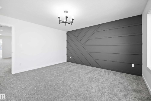 Spare room featuring carpet flooring, a decorative wall, a chandelier, and an accent wall - 38 Cannes Cove, St. Albert, AB - Outdoor With Exterior