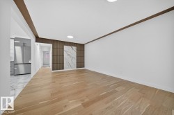 Unfurnished living room featuring light wood-style flooring and an accent wall - 