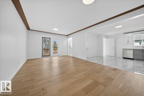 Unfurnished living room featuring light wood-type flooring and baseboards - 12919 113A Street, Edmonton, AB - Indoor Photo Showing Other Room