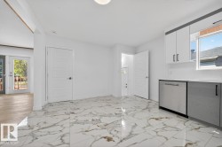 Kitchen featuring healthy amount of natural light, white cabinetry, dishwasher, and backsplash - 