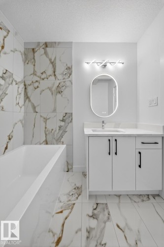 Bathroom with vanity, light marble finish flooring, and a textured ceiling - 12919 113A Street, Edmonton, AB - Indoor Photo Showing Bathroom