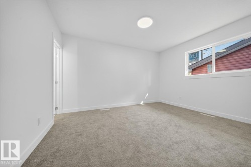 Unfurnished room featuring baseboards and light colored carpet - 12919 113A Street, Edmonton, AB - Indoor Photo Showing Other Room
