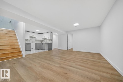 Unfurnished living room with stairs and light wood-type flooring - 12919 113A Street, Edmonton, AB - Indoor Photo Showing Other Room