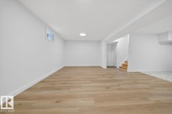 Basement with light wood-style flooring and stairway - 