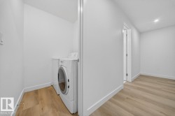 Washroom featuring light wood-style flooring, separate washer and dryer, and recessed lighting - 