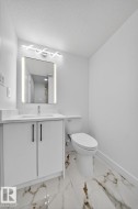 Bathroom with vanity, light marble finish floors, and a textured ceiling - 