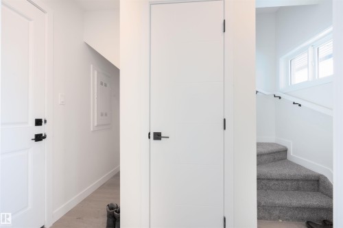 Staircase featuring wood finished floors and electric panel - 64 18120 28 Avenue Sw, Edmonton, AB - Indoor Photo Showing Other Room