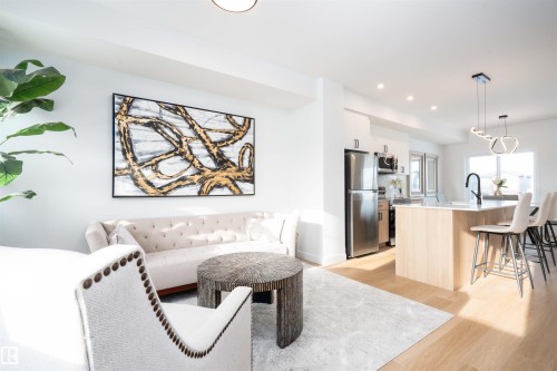 Living area featuring light wood-style flooring and recessed lighting - 64 18120 28 Avenue Sw, Edmonton, AB - Indoor