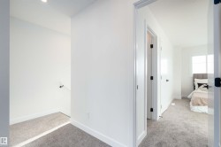 Hall with light colored carpet and baseboards - 