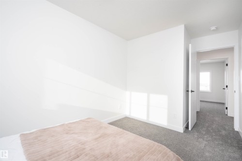 Unfurnished bedroom with baseboards and carpet - 64 18120 28 Avenue Sw, Edmonton, AB - Indoor Photo Showing Other Room