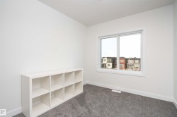 Spare room featuring dark colored carpet and baseboards - 