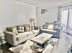 Living room featuring dark wood-style flooring, a textured ceiling, and ornamental molding - 