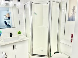 Full bathroom featuring a stall shower, vanity, and decorative backsplash - 