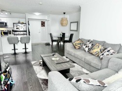 Living area with dark wood-style floors, a textured ceiling, and crown molding - 