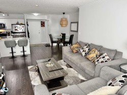 Living room featuring dark wood-style floors, ornamental molding, and a textured ceiling - 