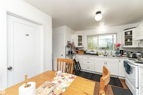 Kitchen with glass insert cabinets, white cabinets, and white electric range oven - 2349 Millbourne Road W, Edmonton, AB - Indoor