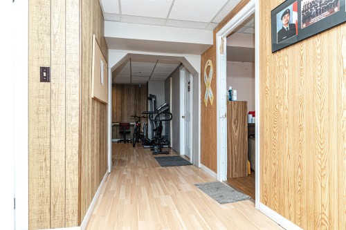 Corridor featuring a paneled ceiling, arched walkways, light wood finished floors, and wood walls - 2349 Millbourne Road W, Edmonton, AB - Indoor Photo Showing Other Room
