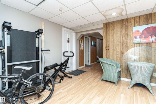Exercise room featuring wooden walls, a paneled ceiling, and arched walkways - 2349 Millbourne Road W, Edmonton, AB - Indoor Photo Showing Gym Room