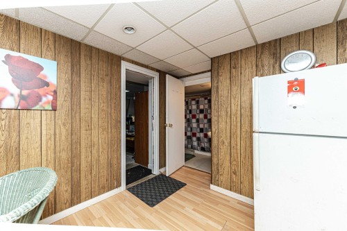 Interior space featuring a drop ceiling, wooden walls, and light wood-type flooring - 2349 Millbourne Road W, Edmonton, AB - Indoor Photo Showing Other Room