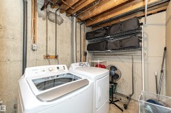Washroom featuring washing machine and clothes dryer and unfinished concrete floors - 