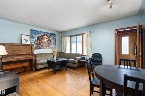 Living room with light wood-type flooring and a textured ceiling - 10124 88 Avenue, Edmonton, AB - Indoor