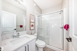 Bathroom with a stall shower, vanity, and light wood-style floors - 