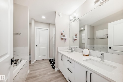 Bathroom featuring double vanity, light wood-type flooring, a garden tub, and recessed lighting - 4930 Hawthorn Place, Edmonton, AB - Indoor Photo Showing Bathroom