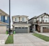 View of front of property with concrete driveway, a garage, and stone siding - 4930 Hawthorn Place, Edmonton, AB  - Outdoor With Facade 